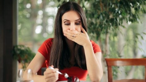 Una mujer después de comer eructa.