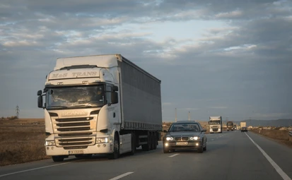 Coche realiza un adelantamiento al camión por el carril izquierdo de la autopista.