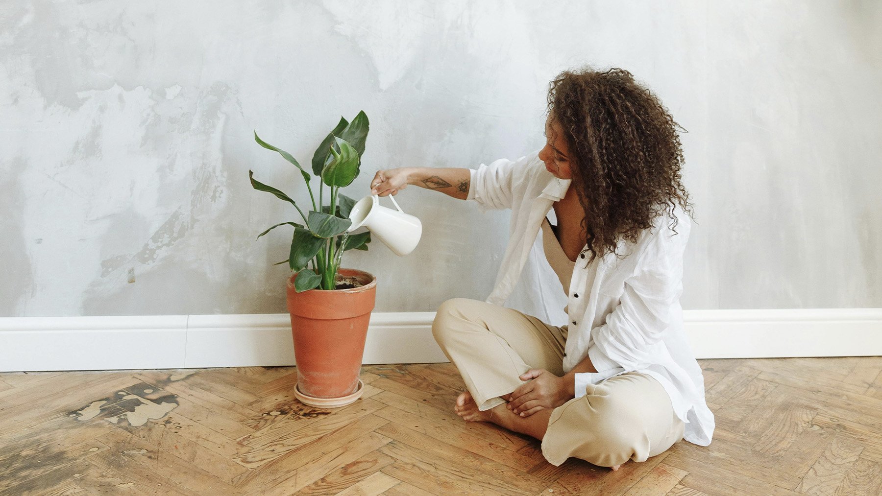 Mujer regando una planta. Foto: Pexels.
