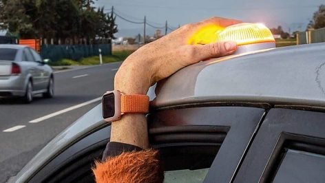 Conductor coloca la baliza V16 en el techo de su coche.