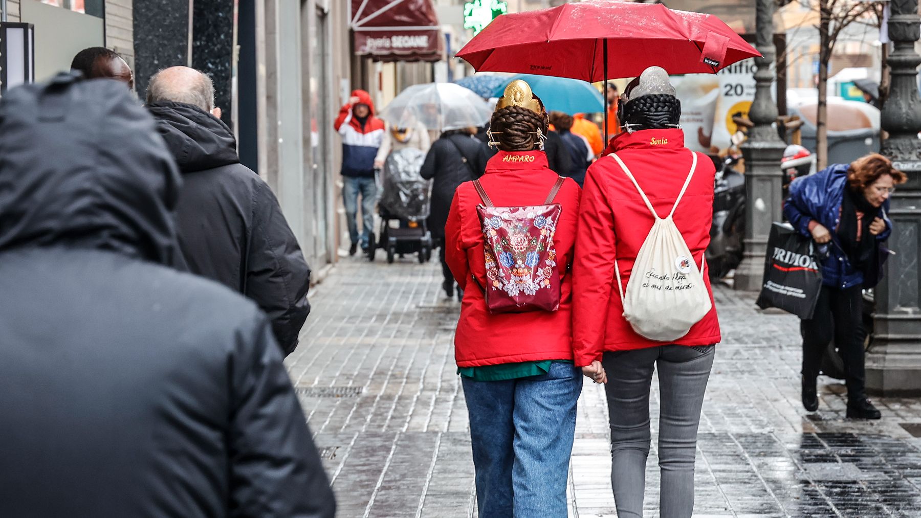 Dos falleras se cubren de la lluvia con un paraguas. (Foto: AEMET)