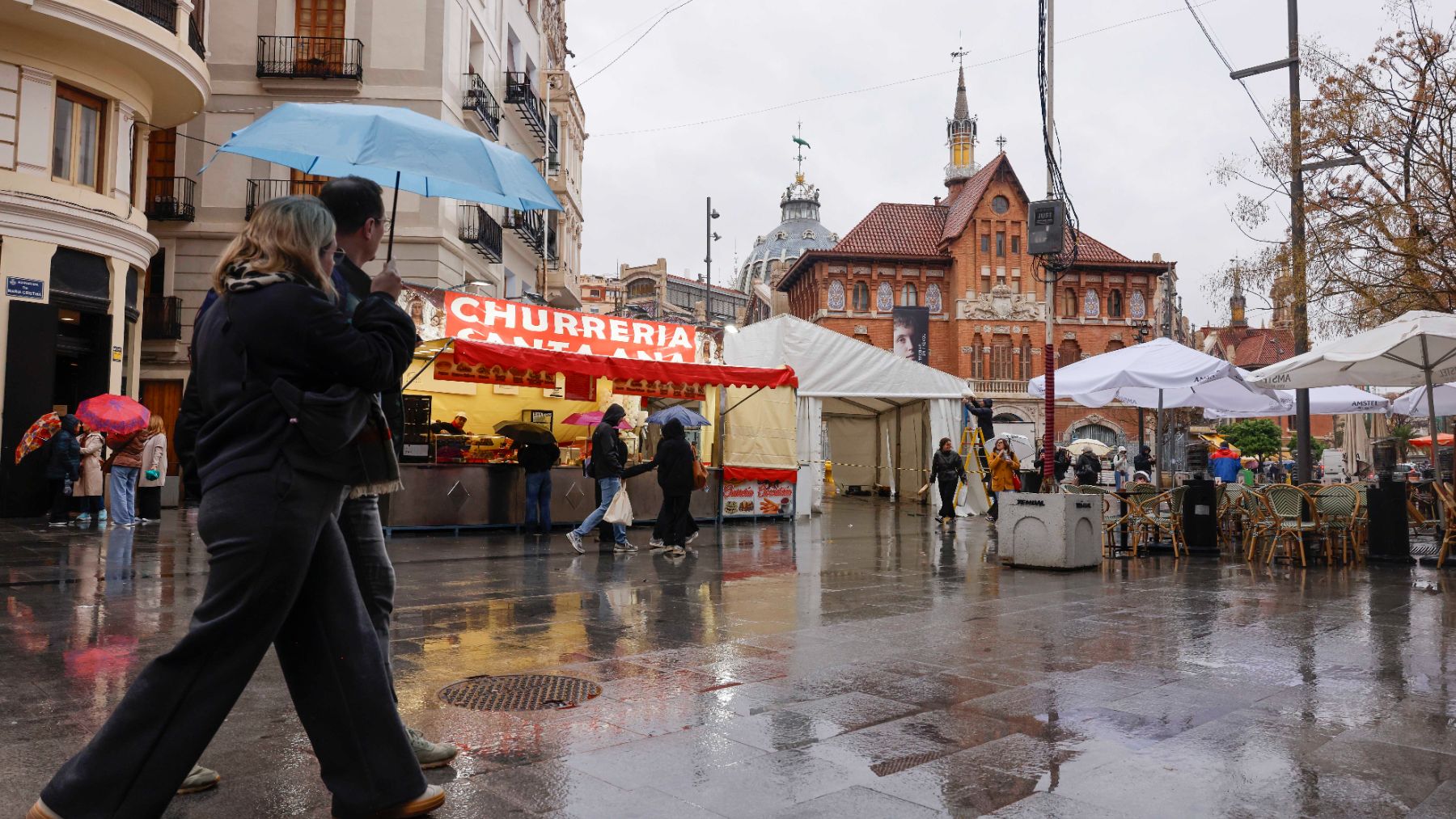 Operarios instalan carpas bajo la lluvia durante el montaje de las Fallas 2026. (Foto: EP)