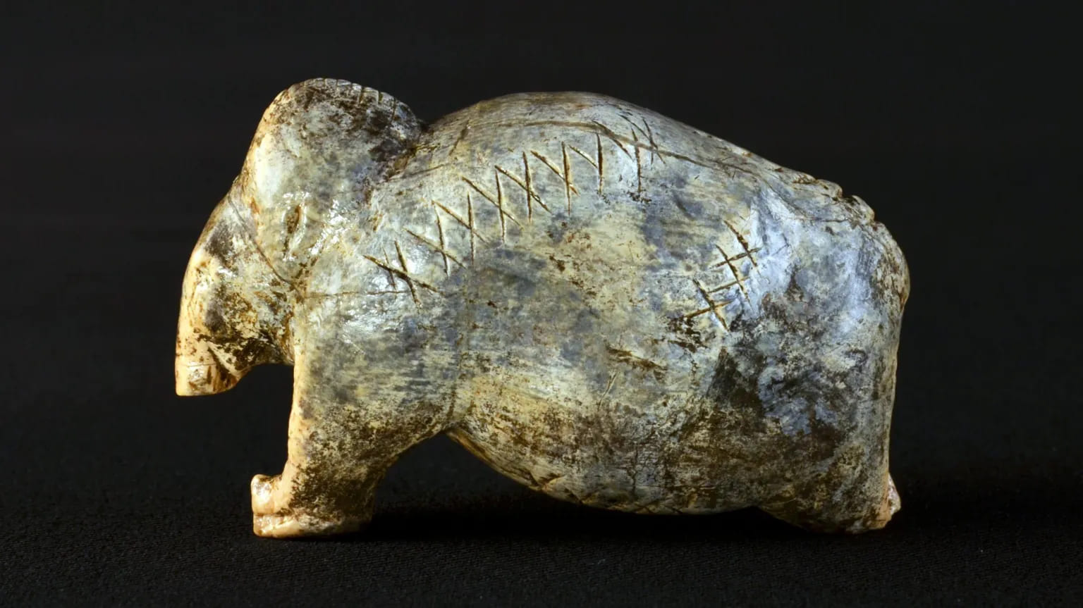 Una figura de mamut de 40.000 años de antigüedad con filas de cruces y puntos grabados.