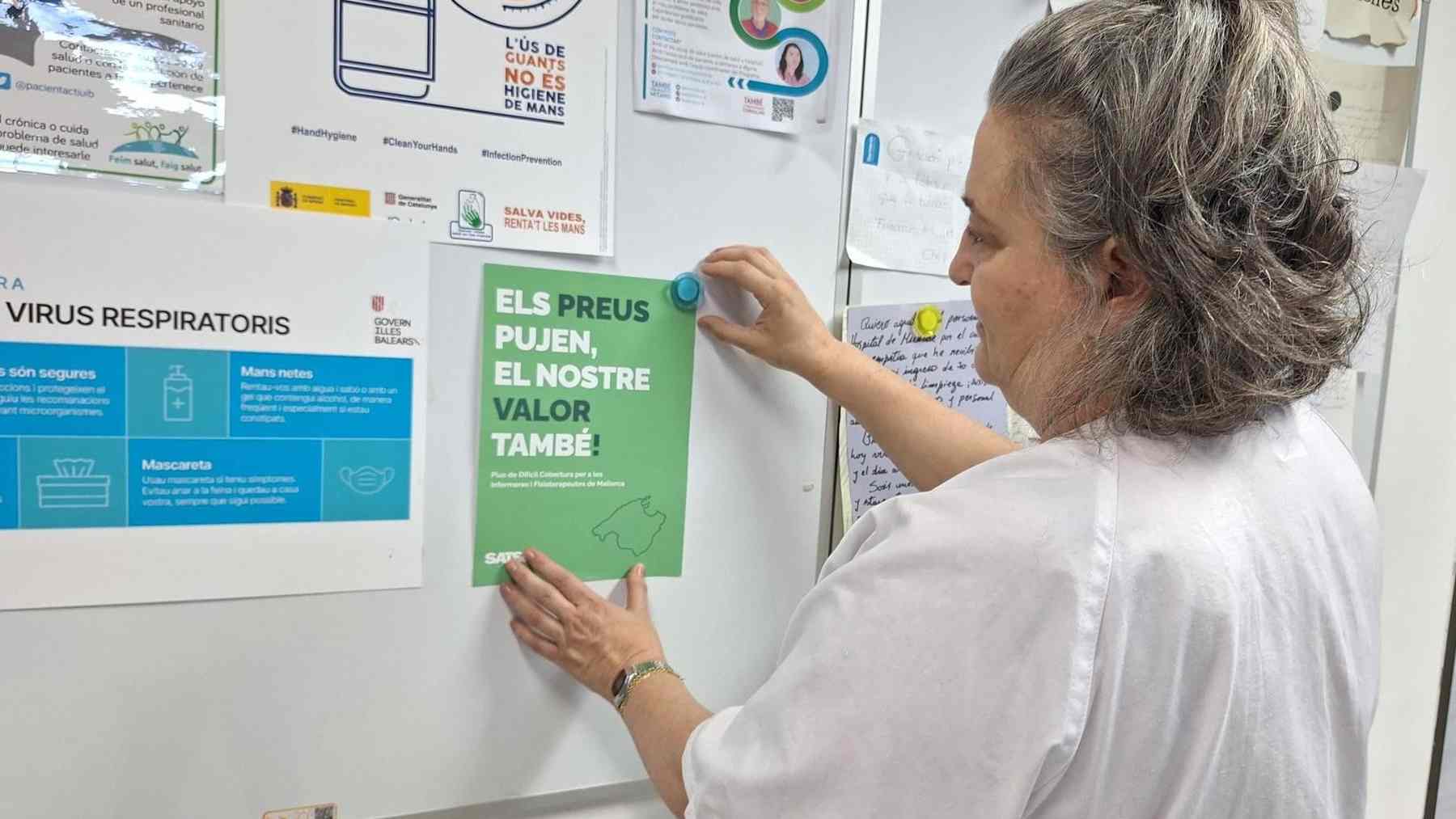 Una enfermera cuelga un cartel de la campaña para reclamar un plus de difícil cobertura en Mallorca.