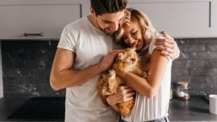 Pareja abrazando a su gato. (Foto: Freepik)