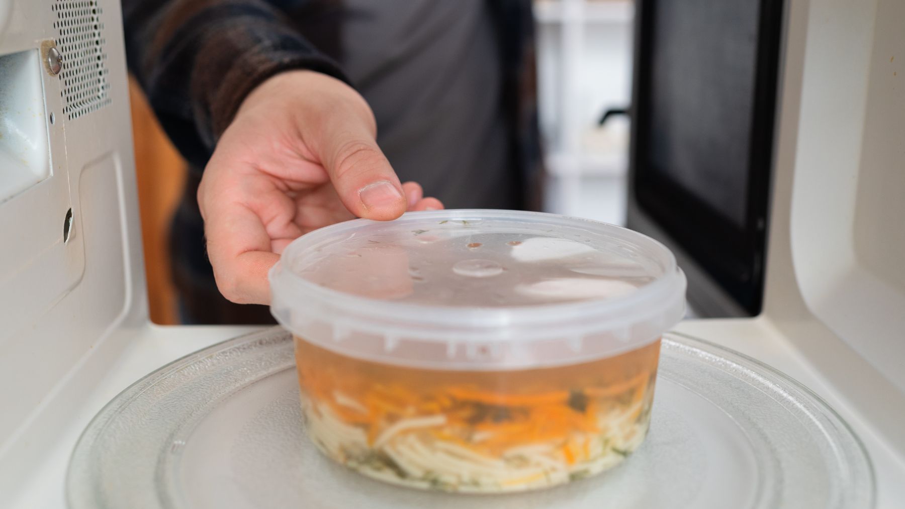 Un recipiente de plástico con comida dentro del microondas.