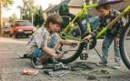 Dos niños arreglando una bicicleta. Imagen generada con IA.