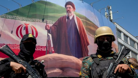 Los miembros de la Guardia Nacional de Irán bajo un cartel de Mojtaba Jamenei. (Getty)