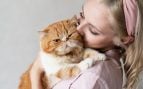 Mujer abrazando un gato naranja. Foto: Freepik
