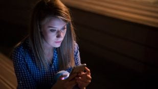 Una mujer preocupada sostiene su móvil. Foto: Freepik