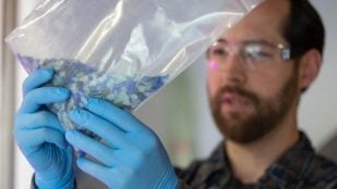 El cofundador de Vitriform3D, Alex Stiles, sostiene una bolsa de vidrio que se utilizará para crear un nuevo producto. Crédito: Amy Smotherman Burgess/ORNL, EE. UU. Departamento de Energía