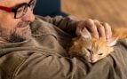 Un hombre acaricia a su gato. Foto: Freepik