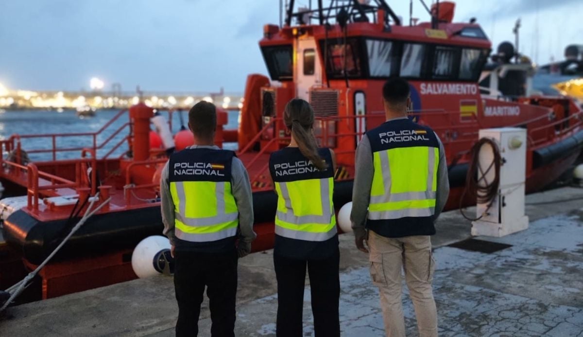 Tres agentes de la Policía Nacional esperando la llegada de una patera rescatada por Salvamento Marítimo.
