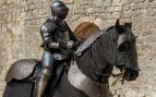 Soldado con armadura de metal sentado en el caballo. Foto: Freepik - @wirestock