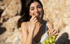 Mujer comiendo uvas un día de verano. Foto: Freepik