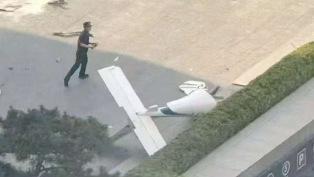 Polic&iacute;a frente a un trozo de avioneta cerca del edificio China Zun - Fotograf&iacute;a cedida
