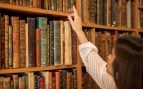 Una mujer elige un libro clásico en la biblioteca. Foto: Freepik