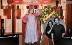 La actriz Ascen López en una imagen de la presentación de Muertos S.L. junto a una imagen de los hermanos Caballero, creadores de la serie (Movistar Plus+/Instagram).
