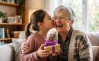 Niña besando a su abuela (Adobe)