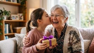 Niña besando a su abuela (Adobe)