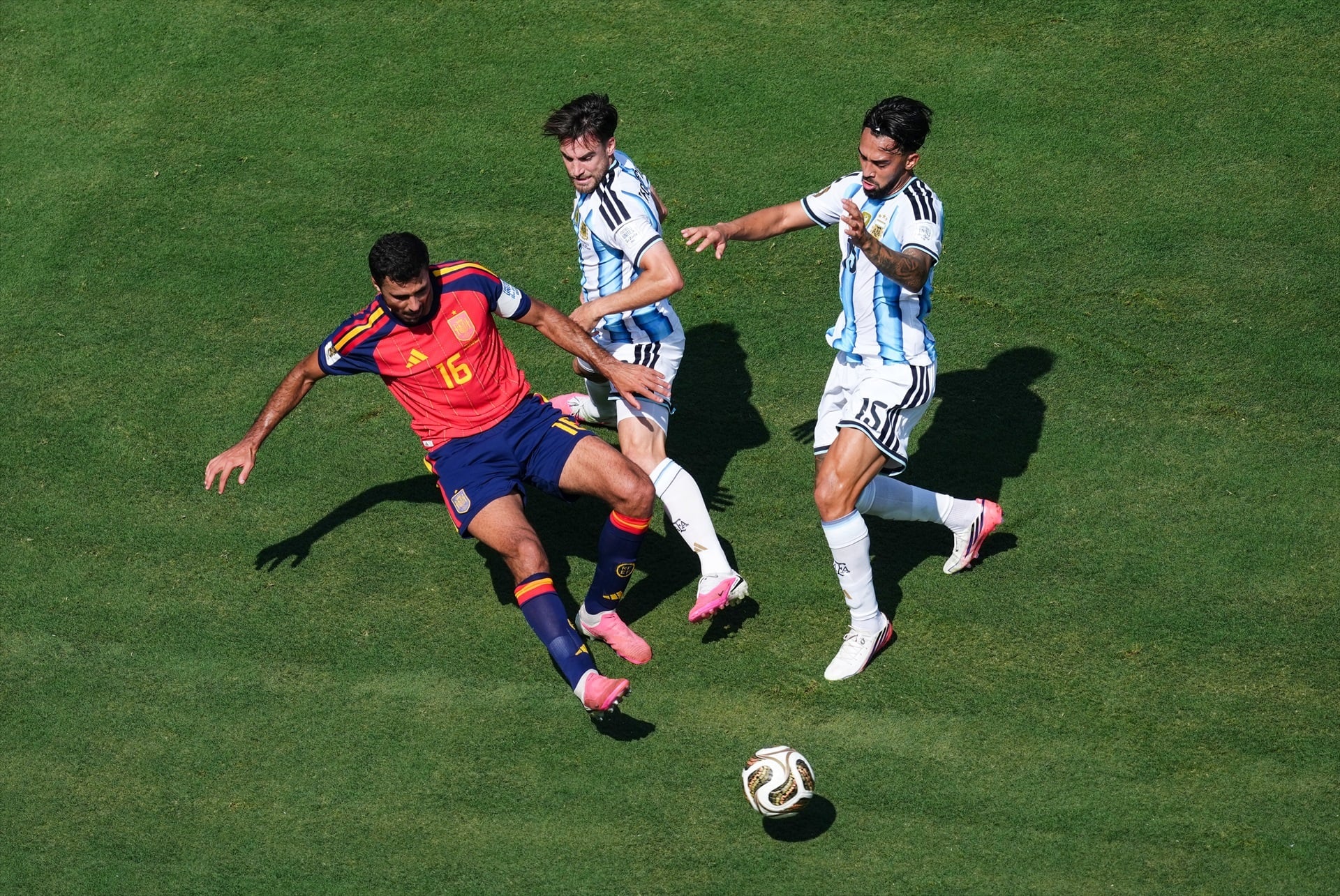 Dos jugadores de Argentina se echan sobre Rodri. (E.P.)