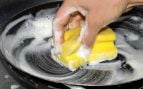 Fregando los platos con estropajo.