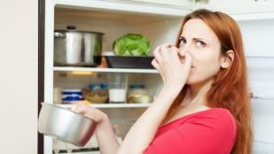 Una mujer se cubre la nariz por el mal olor que desprende un alimento. Foto: Freepik - bearfotos