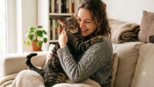 Una persona con su gato en el sofá