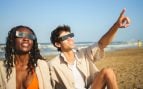 Dos personas observando un eclipse con gafas de protección.