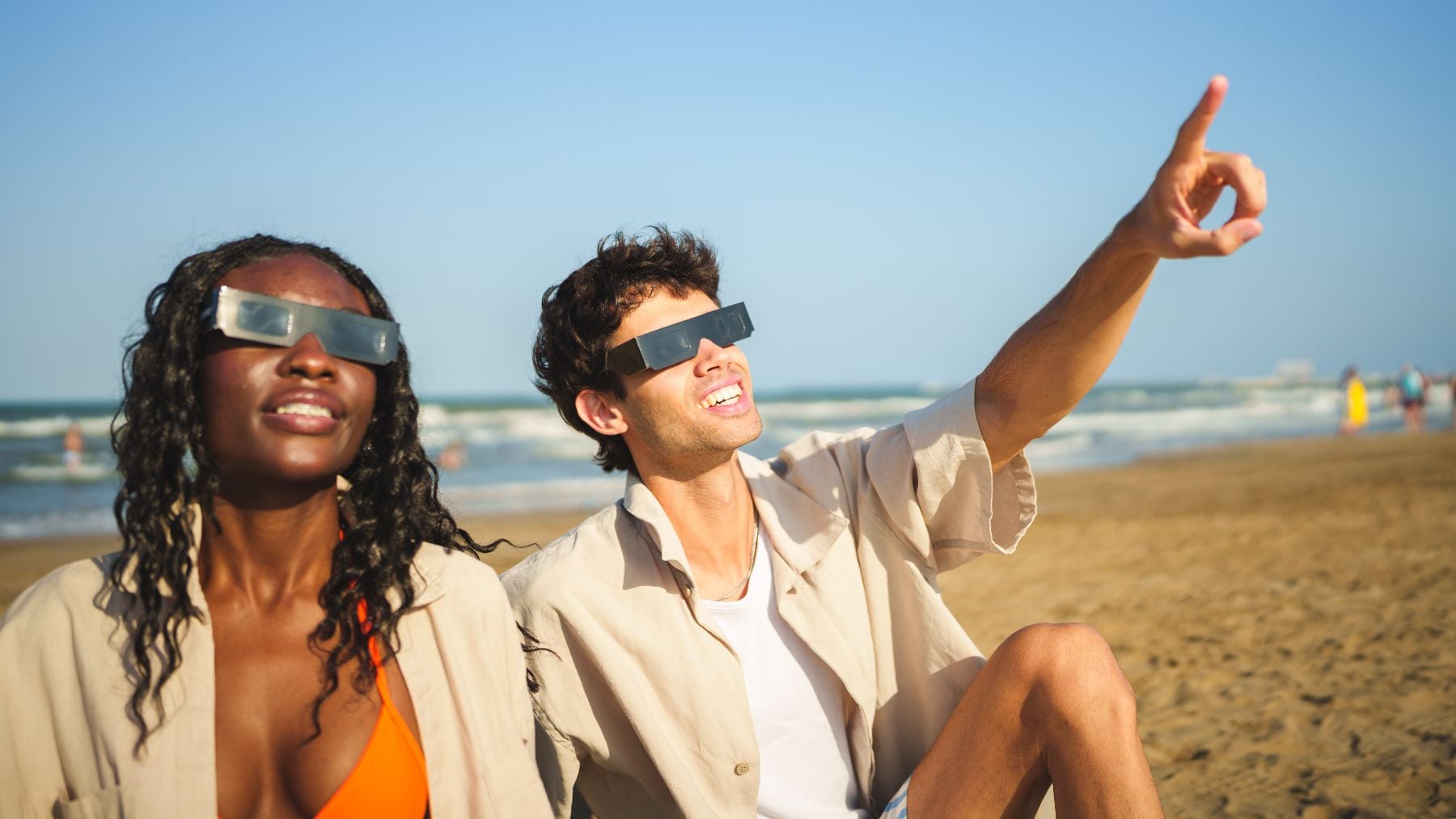 Dos personas observando un eclipse con gafas de protección.