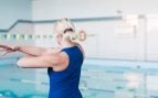 Una mujer mayor realiza ejercicios en una piscina. Foto: Magnific