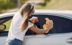Una mujer limpia el coche bajo el sol. Foto: Magnific - @prostooleh