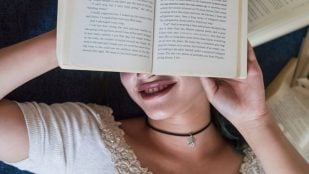 Mujer joven con libro. Foto: Magnific