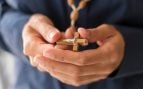 Persona sosteniendo un rosario con una cruz. Foto: Magnific