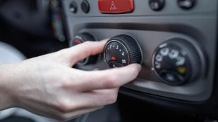 Mano encendiendo el sistema de aire acondicionado del coche. Foto: Freepik - @stefamerpik