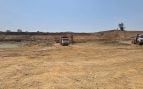 Una excavadora carga tierra en un camión volcador junto al cauce de agua durante las obras de excavación del complejo de la presa Daudhan. Foto: Autoridad del Proyecto de Enlace Ken-Betwa