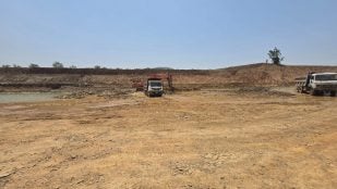 Una excavadora carga tierra en un camión volcador junto al cauce de agua durante las obras de excavación del complejo de la presa Daudhan. Foto: Autoridad del Proyecto de Enlace Ken-Betwa
