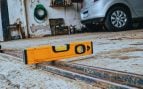 Nivel de burbuja colocado sobre el carril de una puerta corredera de garaje