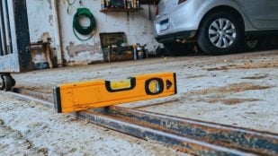 Nivel de burbuja colocado sobre el carril de una puerta corredera de garaje