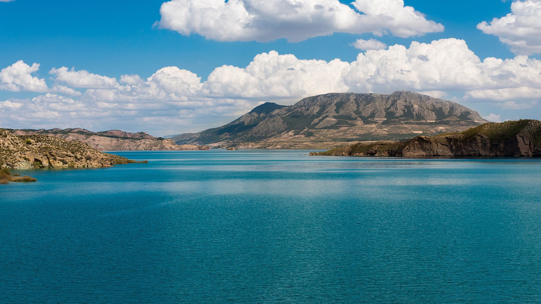 Aguas turquesas, gaviotas, chiringuito y kayak: parece que estás en la playa, pero el embalse más grande de Granada tiene la mejor piscina natural de España sin pisar la costa