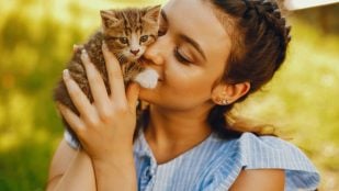 Una mujer sostiene a su gato en brazos. Foto: prostooleh / Freepik.