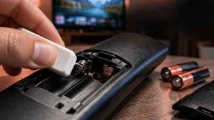 Goma de borrar limpiando los contactos metálicos del compartimento de pilas de un mando a distancia