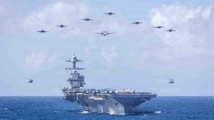 Portaaviones USS Abraham Lincoln navegando con aviones y helicópteros de su grupo aéreo en formación