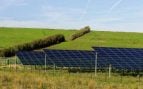 Filas de paneles solares instaladas sobre la ladera de un antiguo vertedero cubierto de hierba