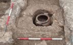 La crátera corintia con los huesos calcinados, aún semienterrada bajo la estructura de travertino que la protegía. Foto: Superintendencia de Arqueología, Bellas Artes y Paisaje de las provincias de Salerno y Avellino.