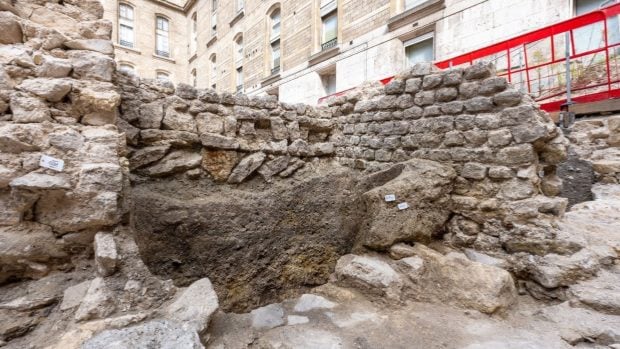 El muro galo hallado en la excavaci&oacute;n del H&ocirc;tel-Dieu, en la isla de la Cit&eacute; de Par&iacute;s, con el edificio del hospital de fondo. Foto: Hamid Azmoun, Inrap
