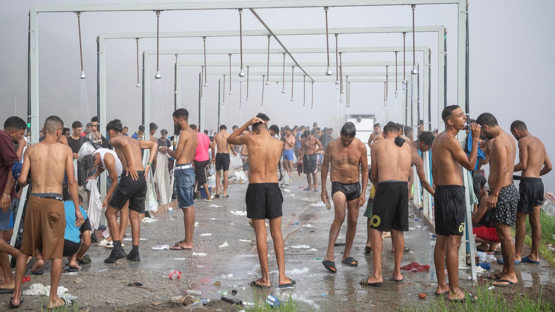 Duchas colectivas en la ceutí en la playa del Trampolín. (Foto: Europa Press).
