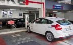 Coches eléctricos cargando junto a un aparcamiento