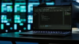 Primer plano del código que se ejecuta en la pantalla de una computadora portátil, en un centro de datos. Foto: Magnific - DC Studio