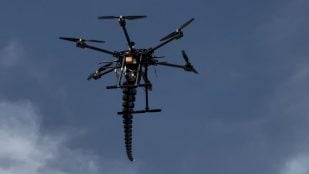 El dron hexacóptero en vuelo con el brazo robótico impreso en 3D colgando bajo el chasis. Foto: Pablo Lima Orrego